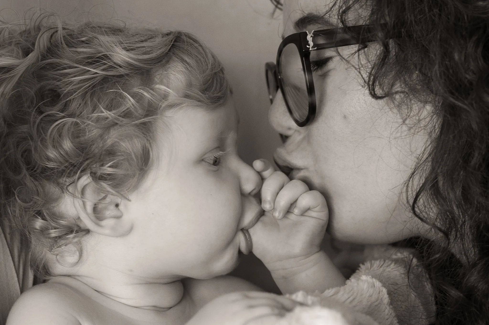 Profil bébé qui suce son pouce, et sa maman, sepia.