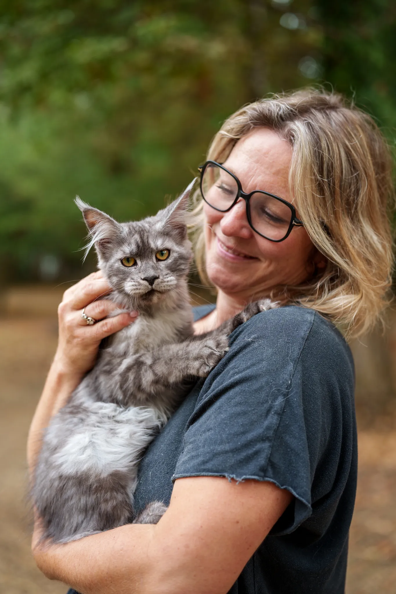 Eleveuse main coon avec son chat dans les bras.