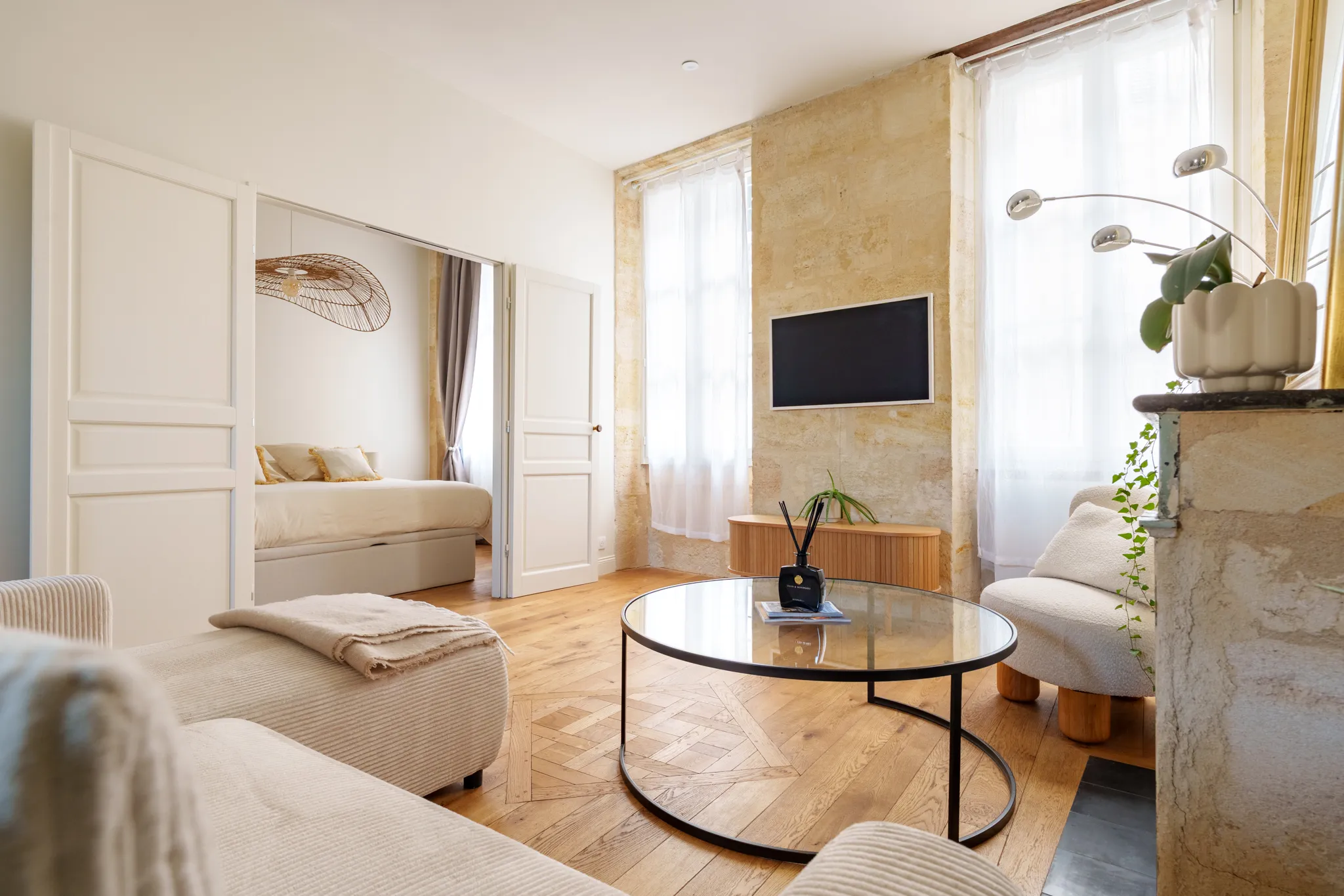 Salon aux tons naturels, parquet miel, murs et cheminée en pierre 