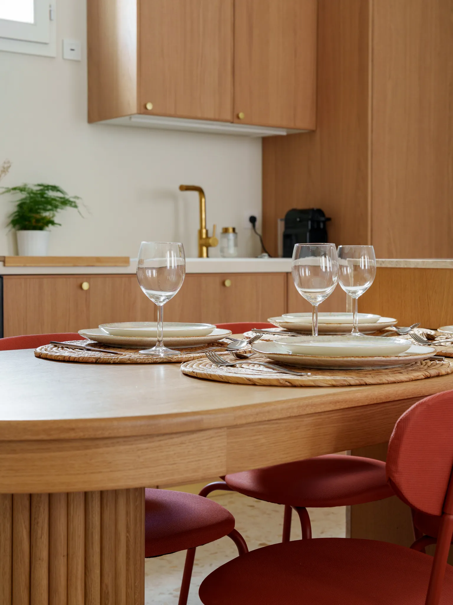 Table dressée dans cuisine moderne et chaleureuse au ton bois, cuivre et terracota