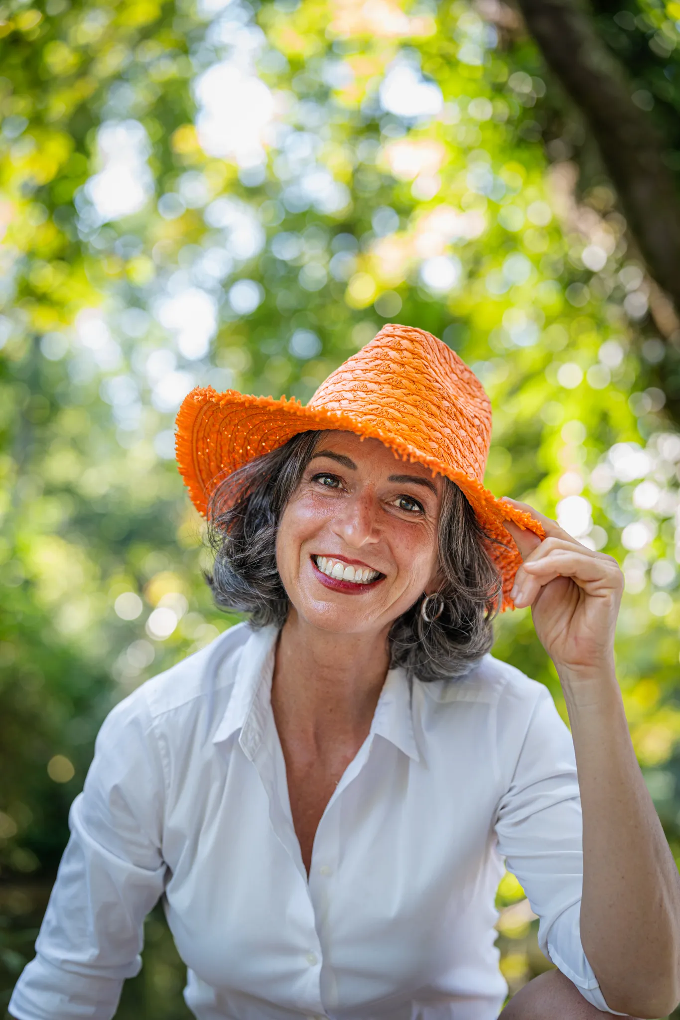 personne souriante avec chapeau orange