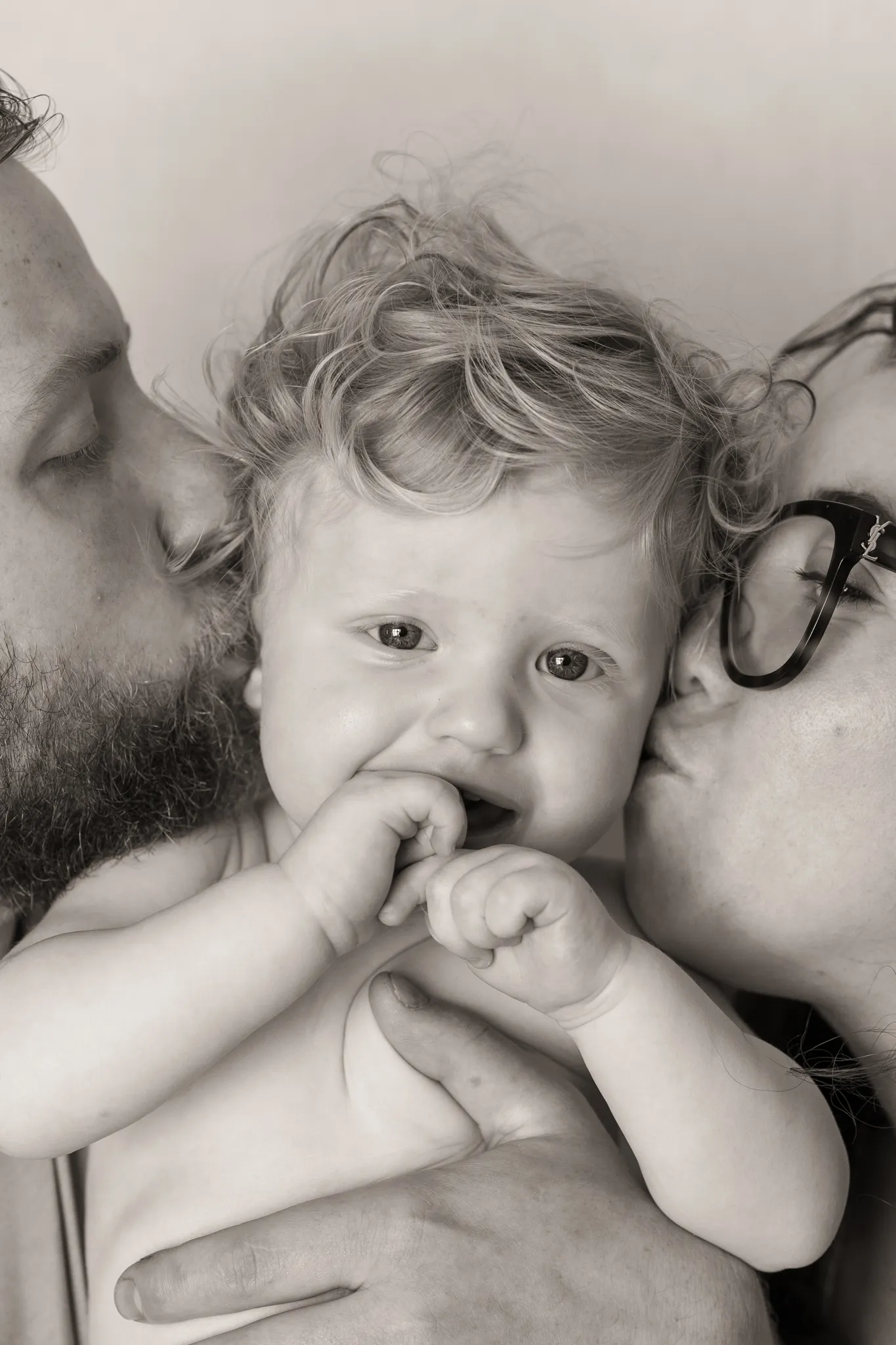 Gros plan sur bébé embrassé par ses parents, sepia.