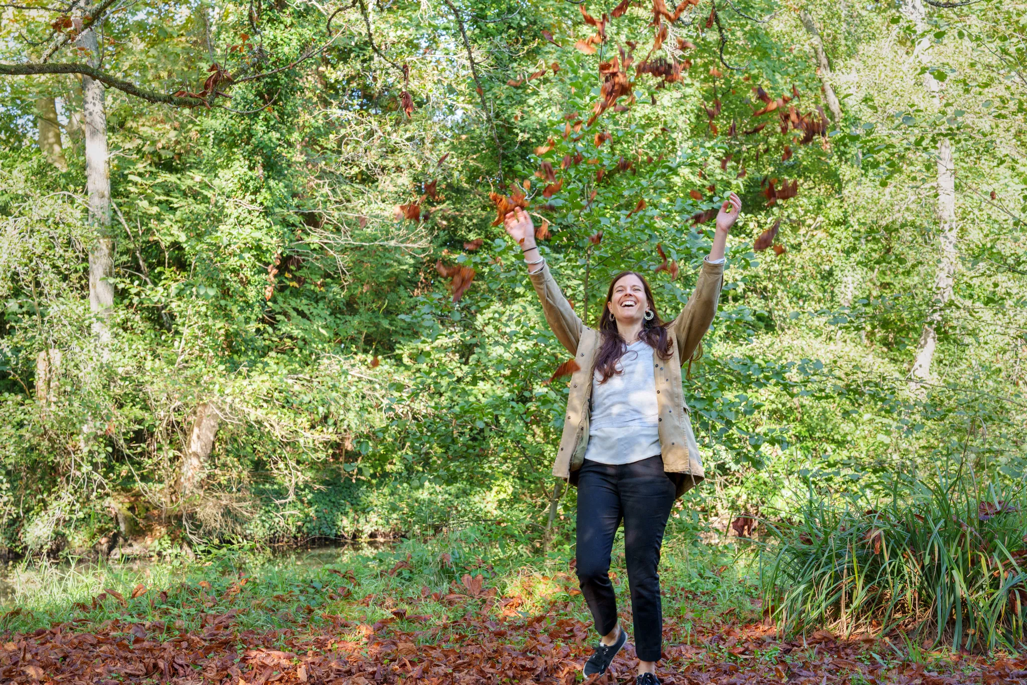 Formatrice joyeuse, jettant des feuilles mortes au dessus de sa tête.