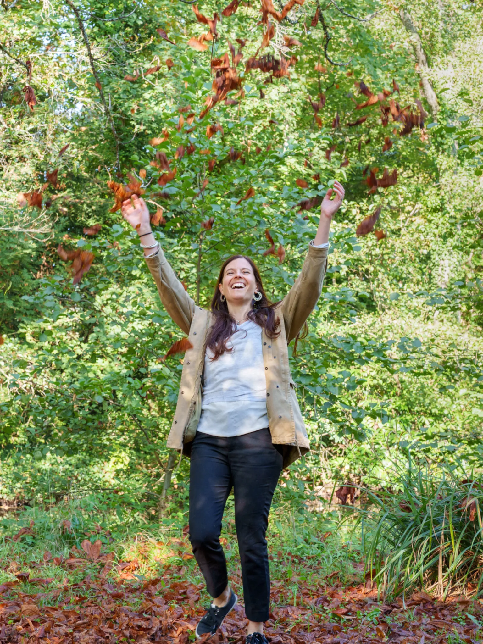 Formatrice joyeuse, jettant des feuilles mortes au dessus de sa tête.