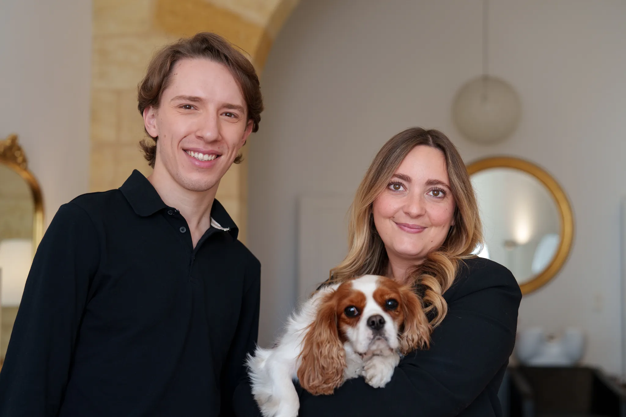 Collaborateurs dans salon de coiffure avec chien dans les bras.
