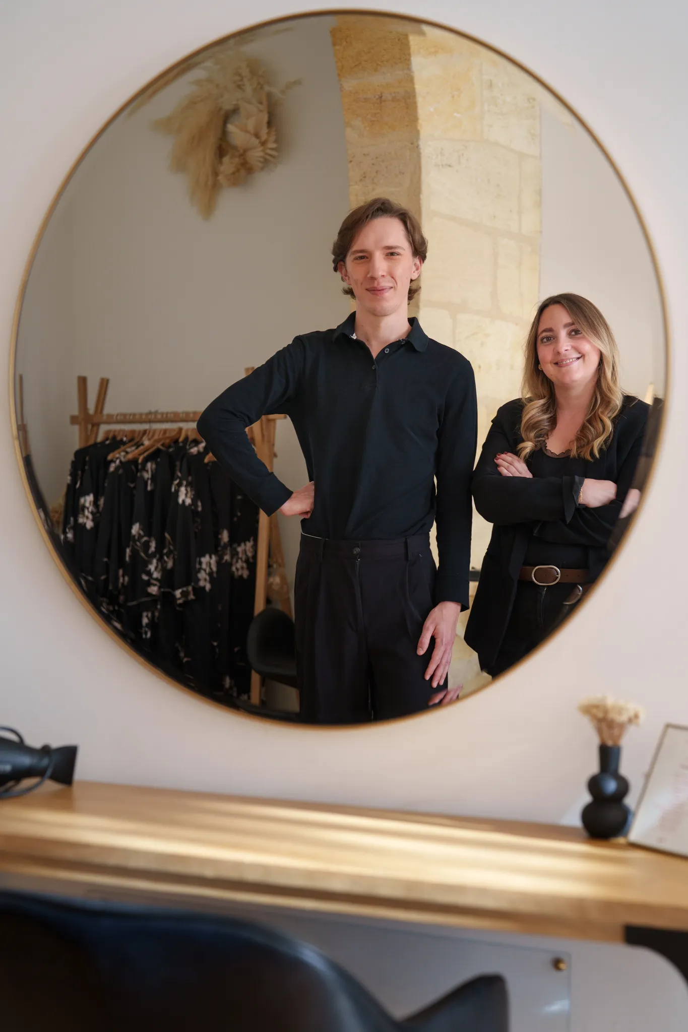 Vue de deux coiffeurs à travers un miroir.