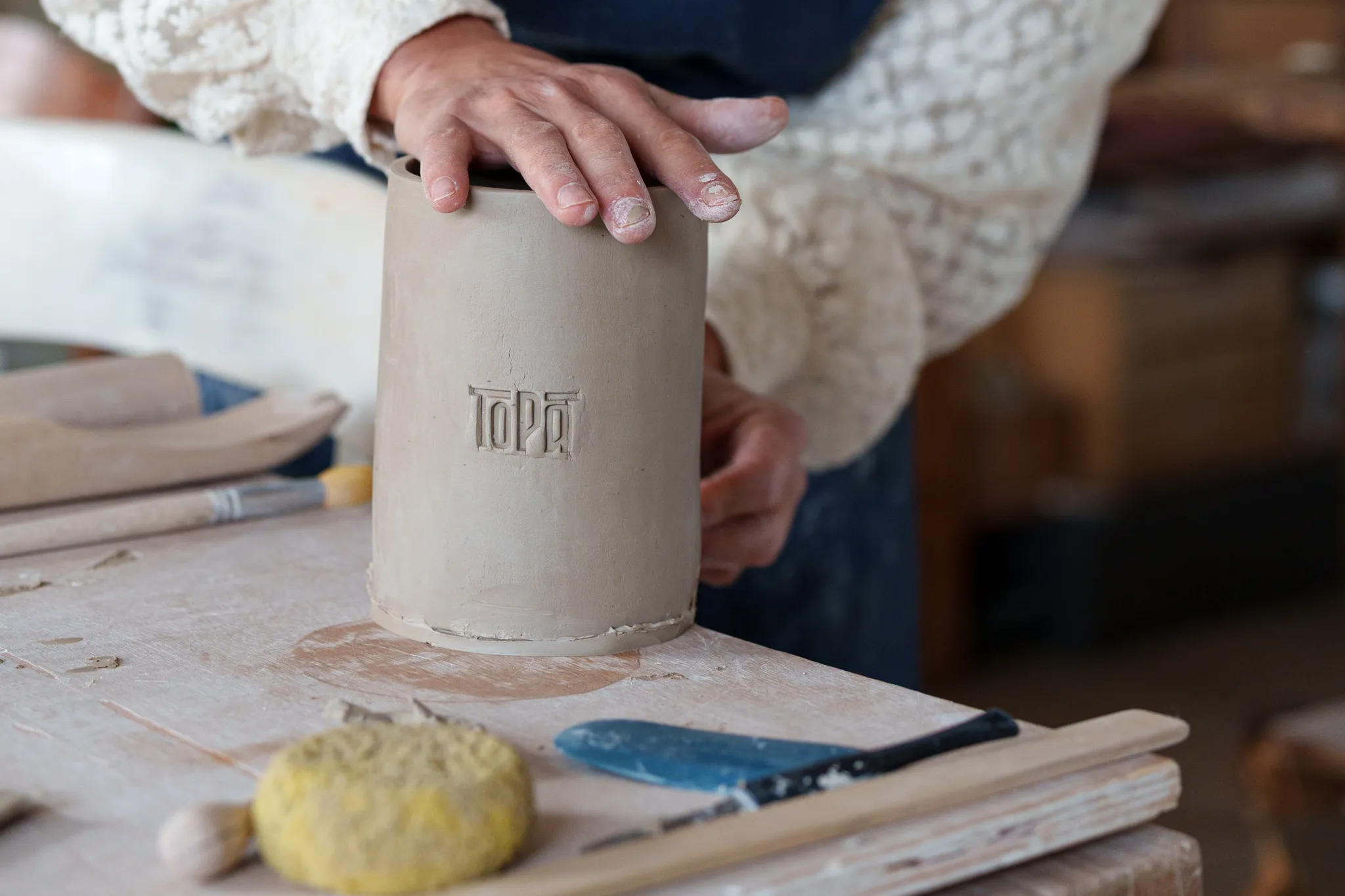 Mains féminines qui travaillent sur une poterie