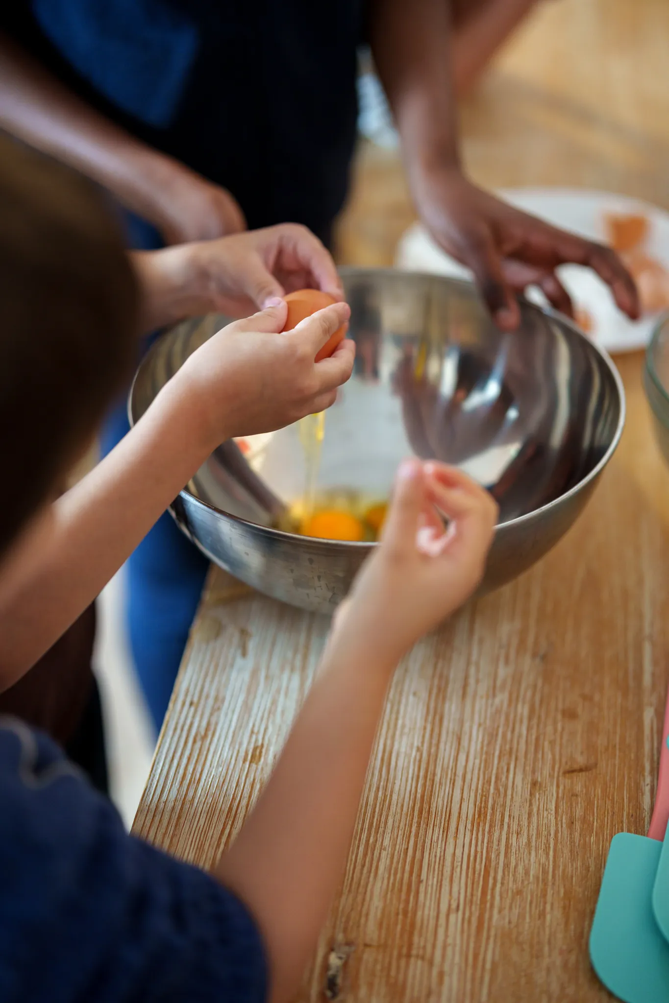 Atelier patisserie enfants qui cassent des oeufs.