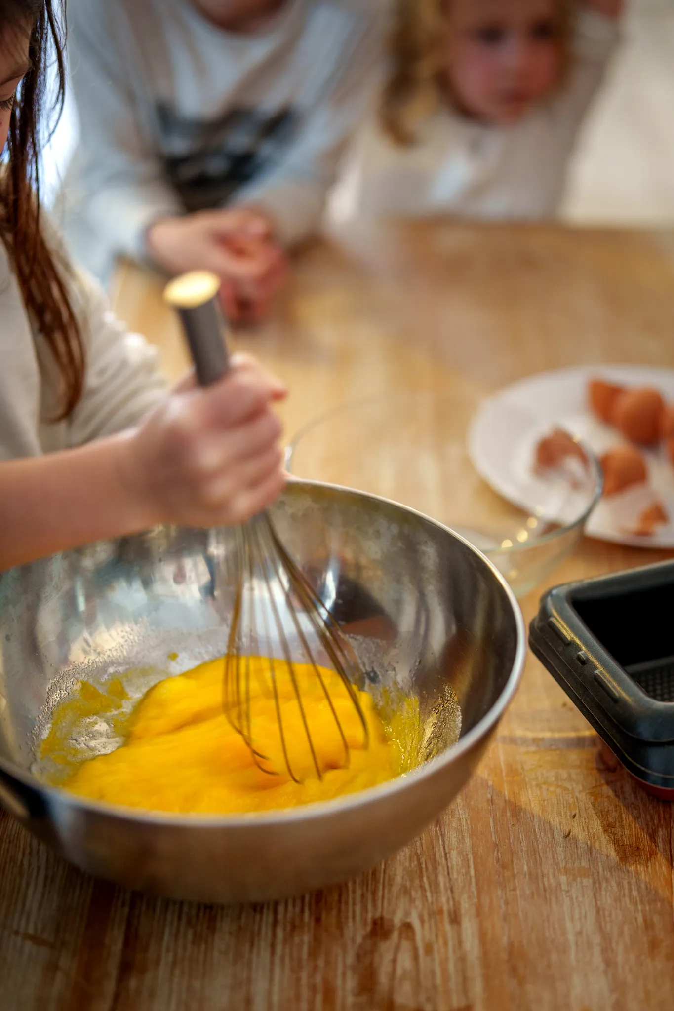 Mains d'enfants qui fouettent des jaunes d'oeufs.